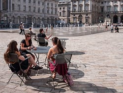 Three friends enjoying the sun in the courtyard of Somerset House London.